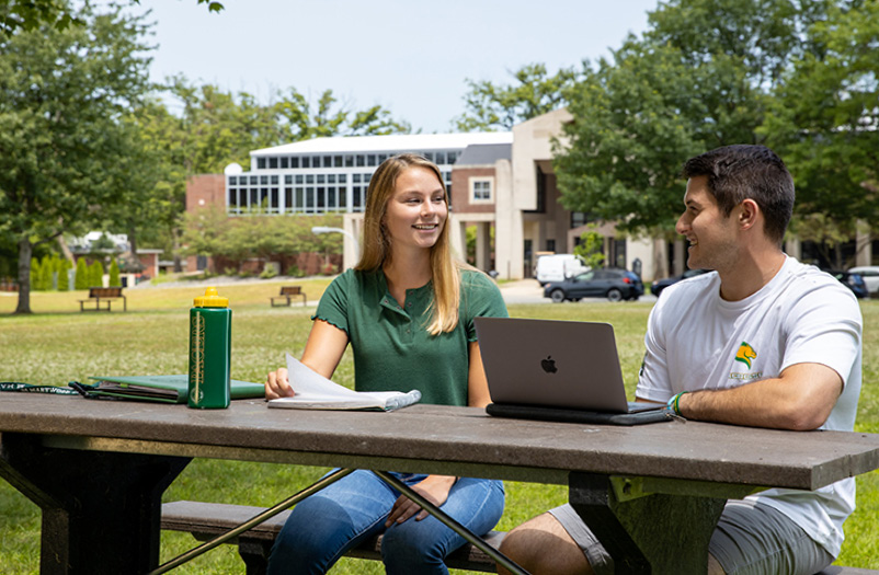 Two Marywood students sitting at a picnic table.